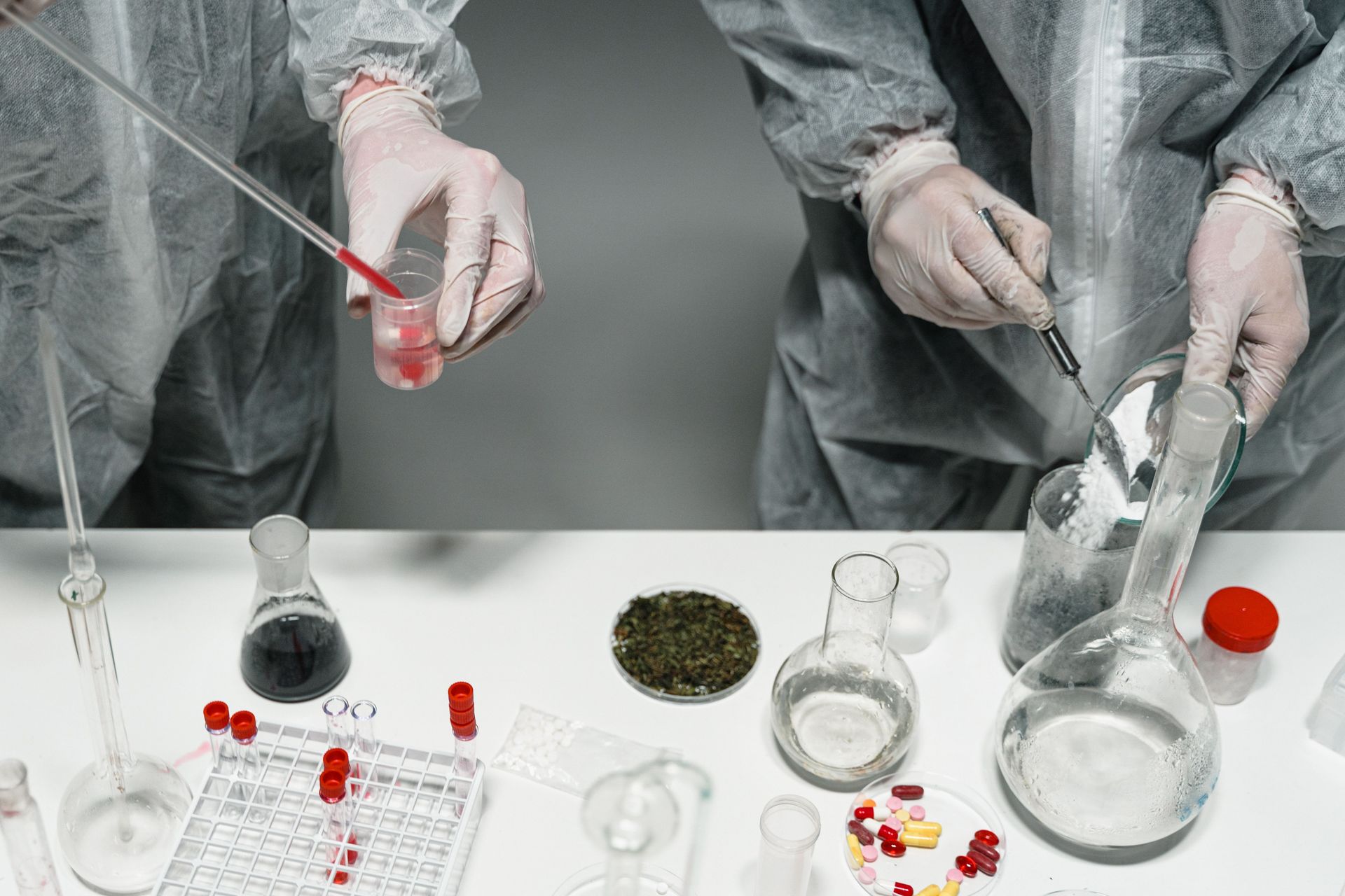 Scientists in protective gear conducting experiments in a modern laboratory setting.